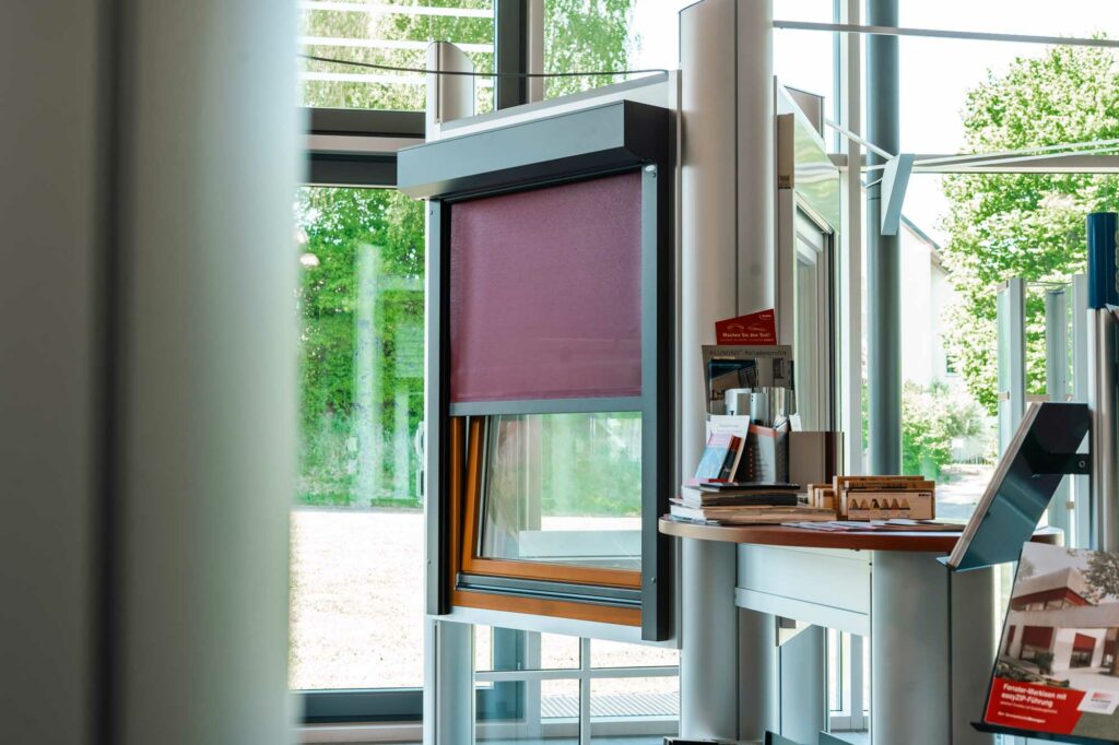 Fenster mit violettem Rollladen-Ausstellungsstück.