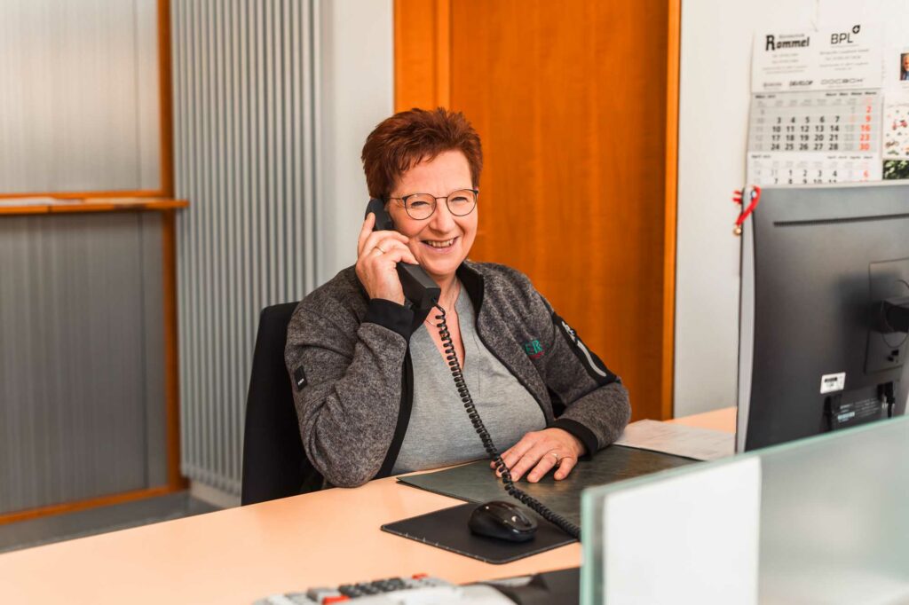 Fröhliche Frau telefoniert im Büro.